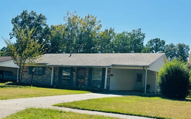 ranch-style home featuring a carport, a front yard, and concrete driveway