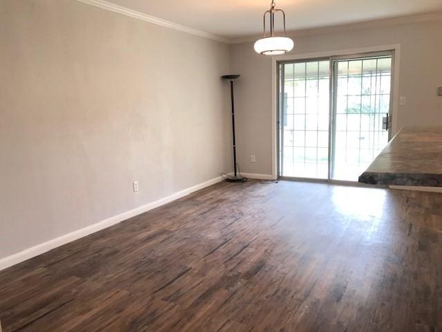 interior space with dark wood-style flooring, crown molding, and baseboards