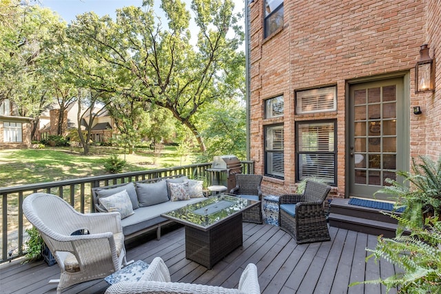 wooden deck with outdoor lounge area and a grill