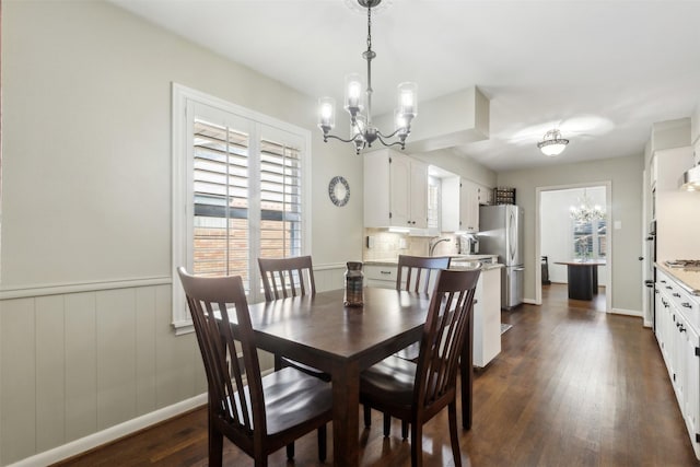 dining area featuring dark wood-type flooring and a chandelier