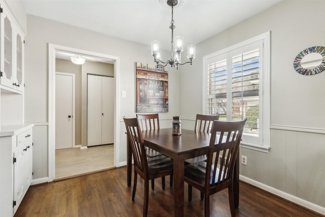 dining room with dark hardwood / wood-style floors and a notable chandelier