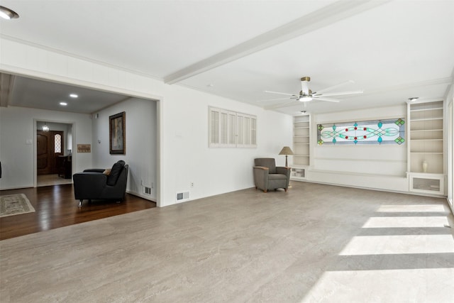 sitting room with ceiling fan, built in shelves, beam ceiling, and hardwood / wood-style floors