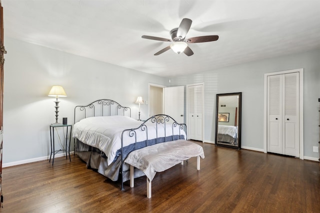 bedroom with multiple closets, dark hardwood / wood-style floors, and ceiling fan