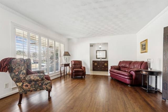 sitting room with dark wood-type flooring and crown molding