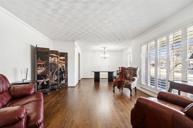 living room featuring dark wood-type flooring, crown molding, and an inviting chandelier