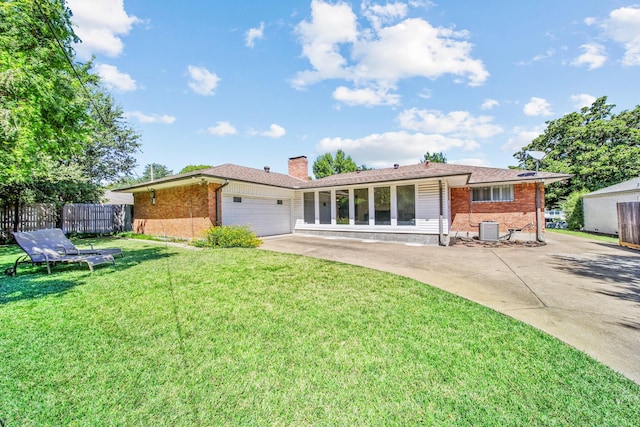 ranch-style house featuring a garage, a front yard, and central air condition unit