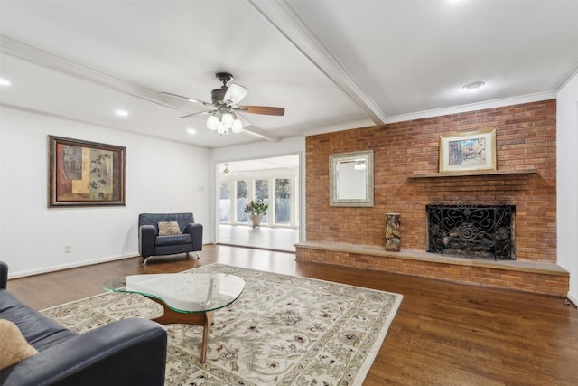 living room featuring a brick fireplace, ceiling fan, dark hardwood / wood-style flooring, ornamental molding, and beam ceiling