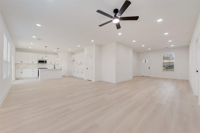 unfurnished living room featuring light wood-type flooring and ceiling fan