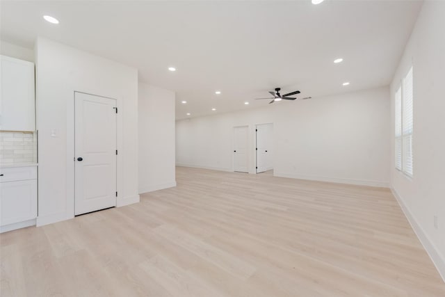 spare room with ceiling fan and light wood-type flooring