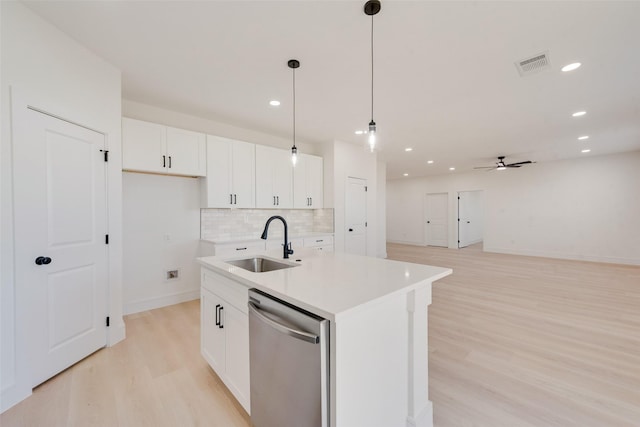 kitchen with white cabinetry, ceiling fan, dishwasher, sink, and a center island with sink