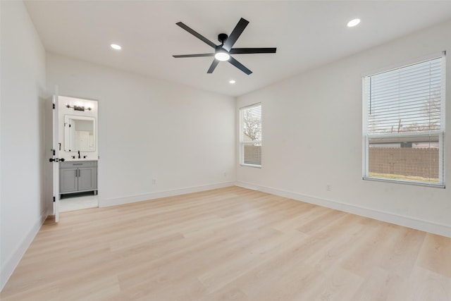 empty room with light hardwood / wood-style floors, ceiling fan, and sink