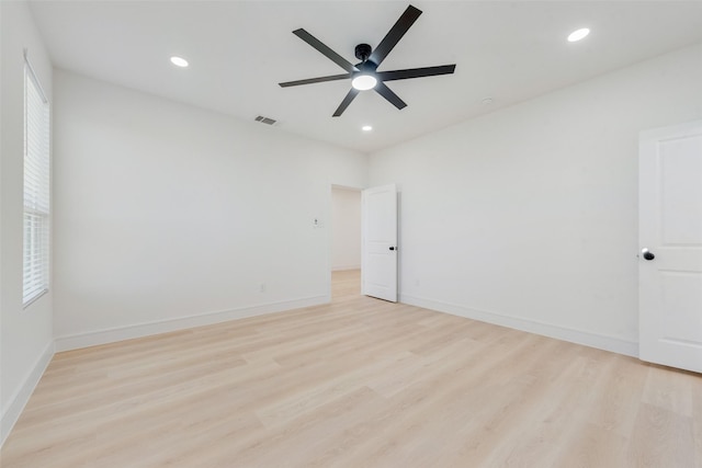 spare room with ceiling fan, a wealth of natural light, and light hardwood / wood-style flooring