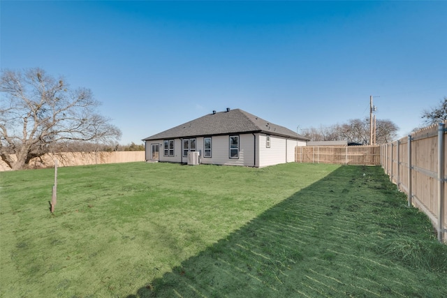 back of house with cooling unit and a yard