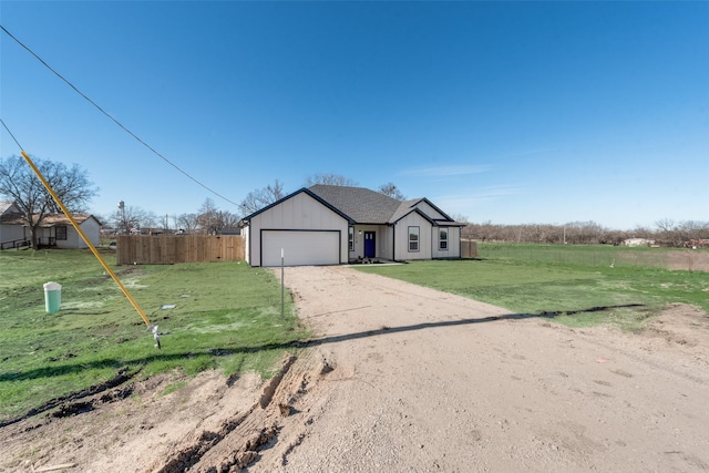 ranch-style house featuring a garage and a front lawn