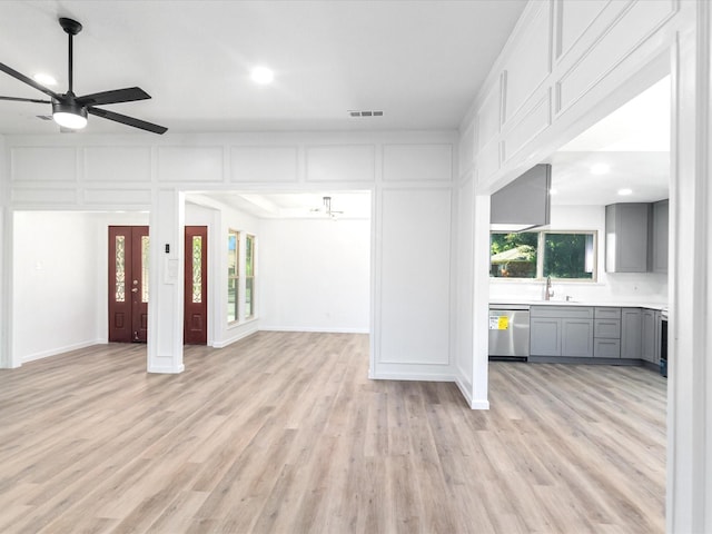 unfurnished living room featuring light wood-type flooring and sink