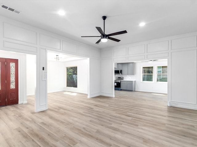 unfurnished living room with ceiling fan, light hardwood / wood-style flooring, and a healthy amount of sunlight