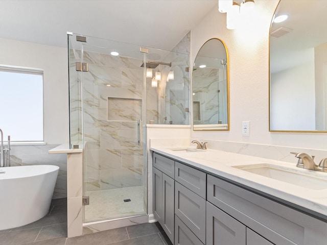 bathroom with tile patterned flooring, vanity, and separate shower and tub