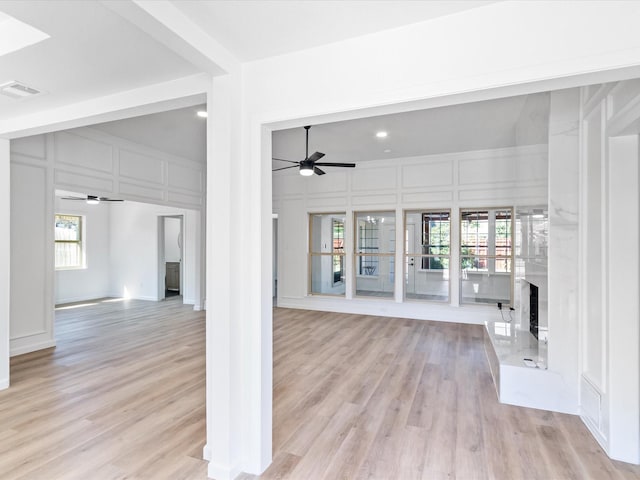 unfurnished living room featuring ceiling fan and light hardwood / wood-style flooring