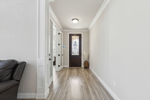 entryway with light wood-type flooring and ornamental molding