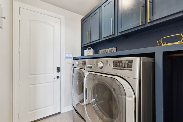 laundry room featuring washer and clothes dryer, cabinets, and light tile patterned floors