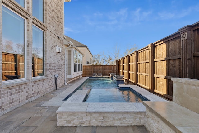 view of pool featuring pool water feature and a jacuzzi