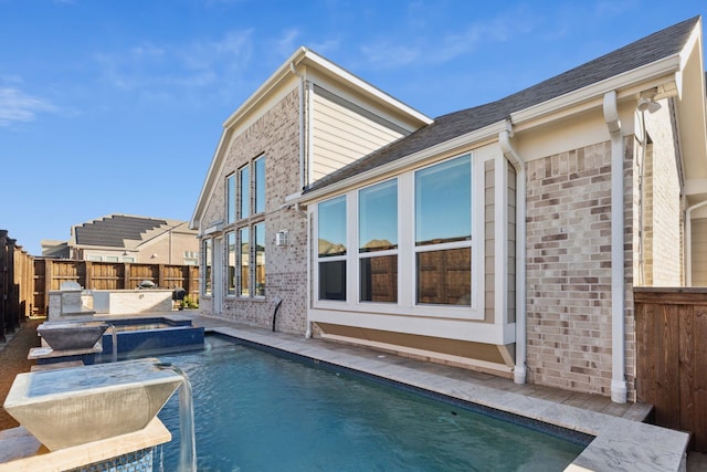 view of swimming pool featuring an in ground hot tub