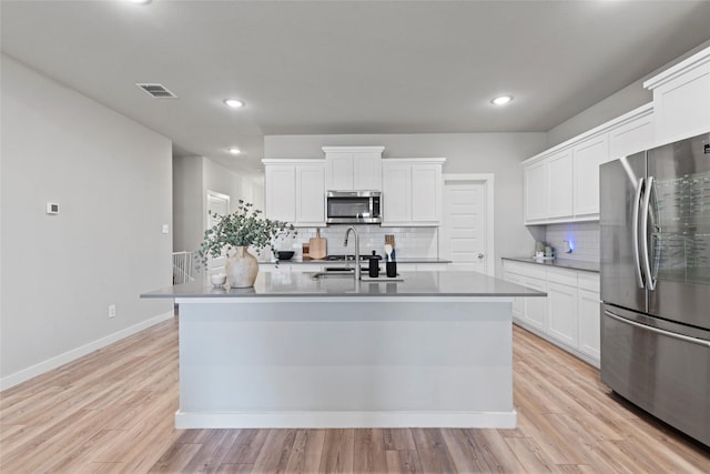 kitchen with a center island with sink, white cabinetry, sink, and appliances with stainless steel finishes