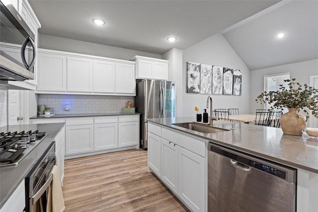 kitchen with decorative backsplash, sink, white cabinets, and appliances with stainless steel finishes