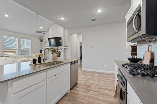 kitchen with appliances with stainless steel finishes, ceiling fan, sink, light hardwood / wood-style flooring, and white cabinets