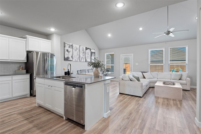 kitchen with a kitchen island with sink, sink, tasteful backsplash, white cabinetry, and stainless steel appliances