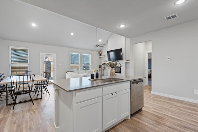 kitchen with a kitchen island with sink, white cabinets, sink, light hardwood / wood-style flooring, and stainless steel dishwasher