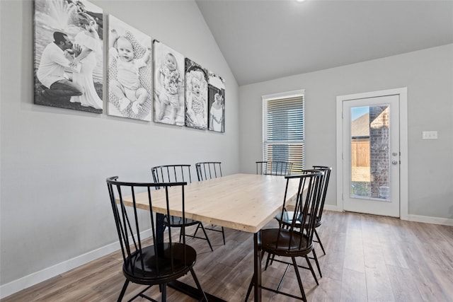 dining room featuring light wood-type flooring and lofted ceiling