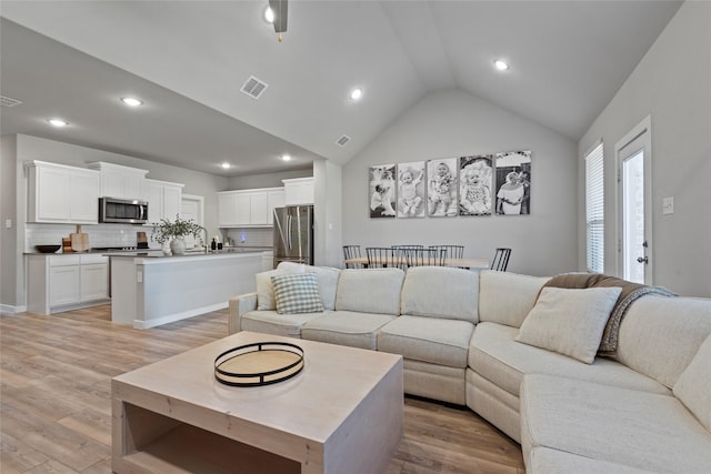 living room with light hardwood / wood-style flooring and lofted ceiling