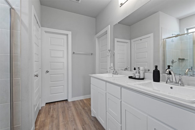 bathroom with vanity, wood-type flooring, and a shower with shower door