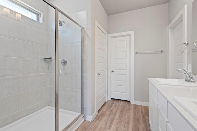 bathroom featuring wood-type flooring, vanity, and a shower with shower door