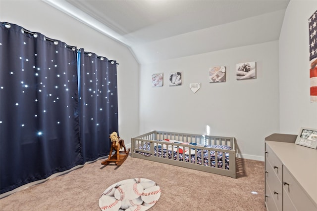 bedroom featuring light carpet, a nursery area, and lofted ceiling