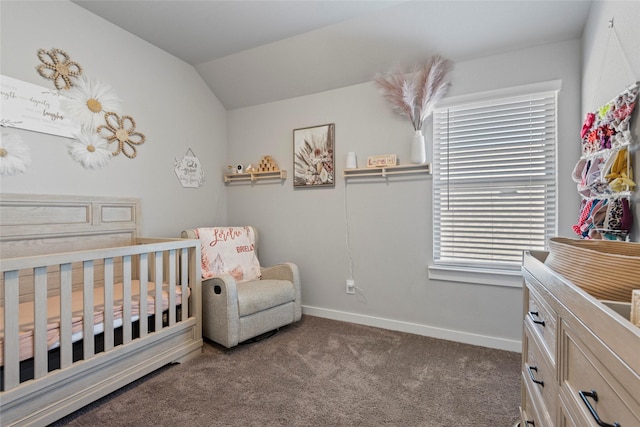 bedroom featuring lofted ceiling, dark carpet, and a crib