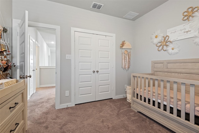 bedroom with a nursery area, carpet floors, and a closet