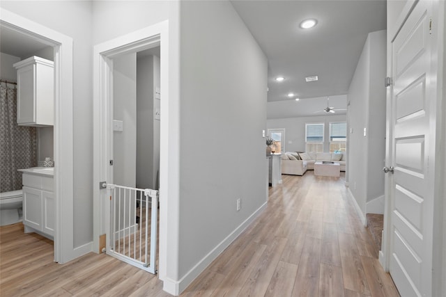 hallway with light hardwood / wood-style floors