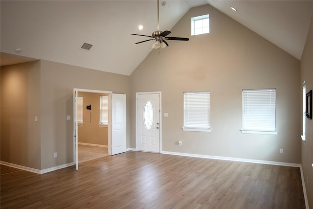 unfurnished living room with light wood-type flooring, high vaulted ceiling, and ceiling fan