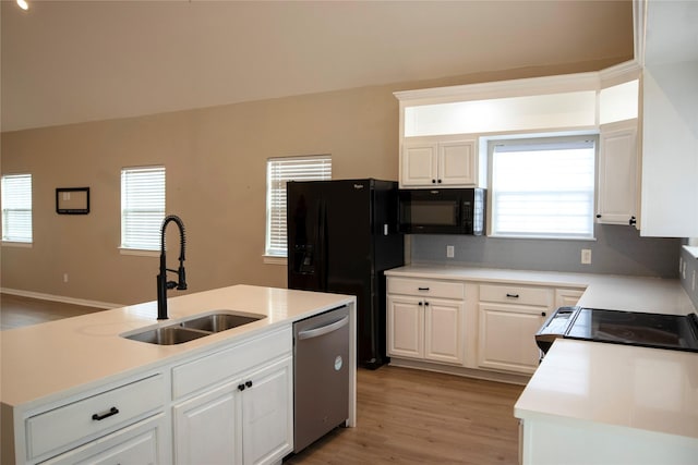 kitchen featuring white cabinetry, sink, light hardwood / wood-style flooring, an island with sink, and black appliances