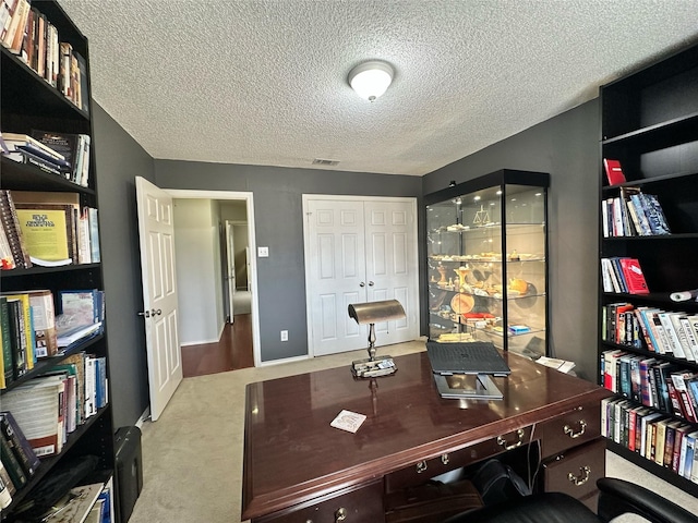 carpeted office space with a textured ceiling