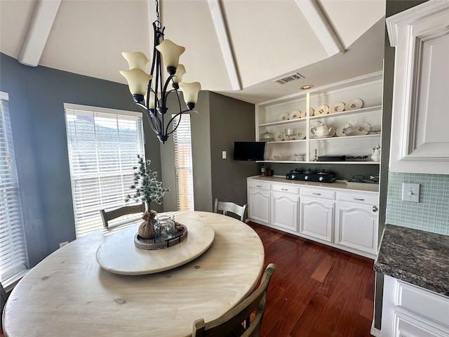 dining room with vaulted ceiling with beams, an inviting chandelier, and dark wood-type flooring