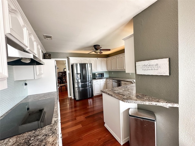 kitchen featuring exhaust hood, dark hardwood / wood-style flooring, white cabinets, and stainless steel appliances