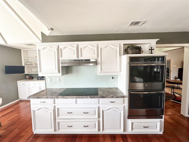 kitchen featuring white cabinets, black electric cooktop, double oven, and dark stone counters