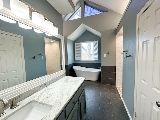 bathroom featuring plus walk in shower, vanity, and vaulted ceiling