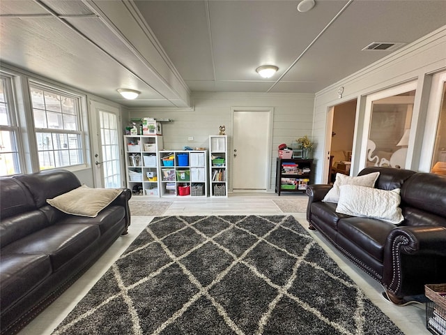 living room featuring wood walls and ornamental molding