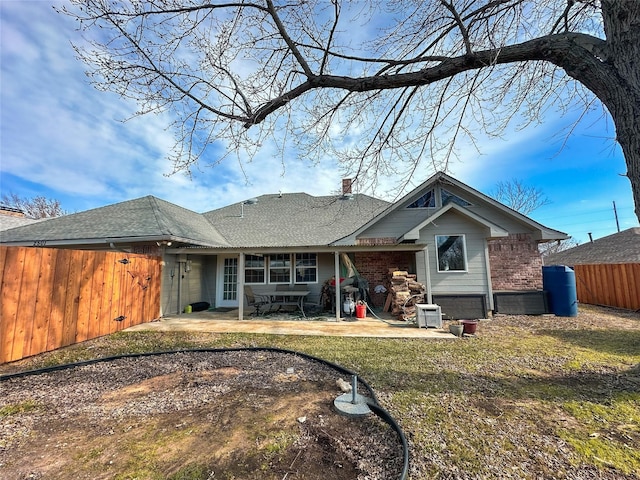 rear view of property featuring a lawn and a patio