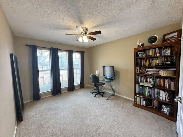 home office with a textured ceiling, light colored carpet, and ceiling fan