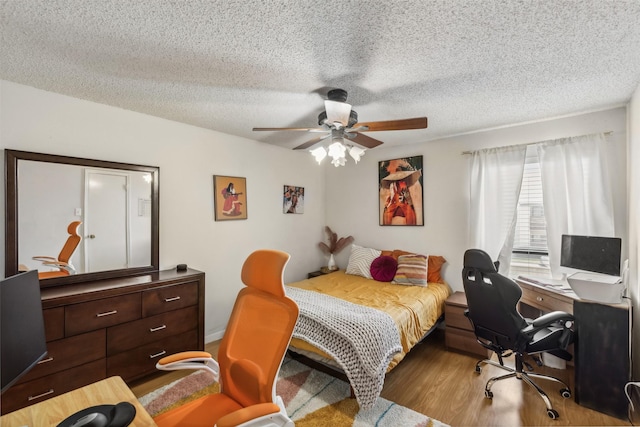 bedroom featuring ceiling fan, a textured ceiling, and light hardwood / wood-style flooring